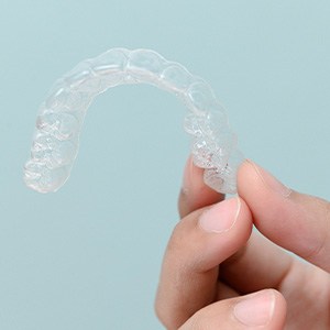 Closeup of patient holding clear aligner