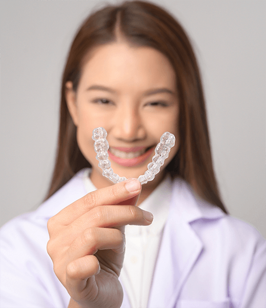 Dentist holding an Invisalign aligner